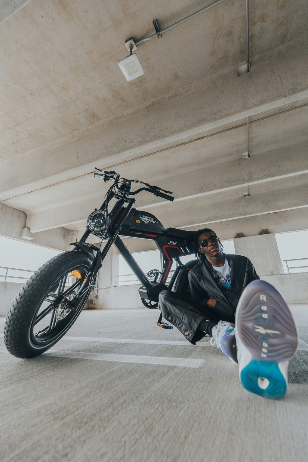 Moped-style compact fat-tire e-bike parked under dramatic red lighting