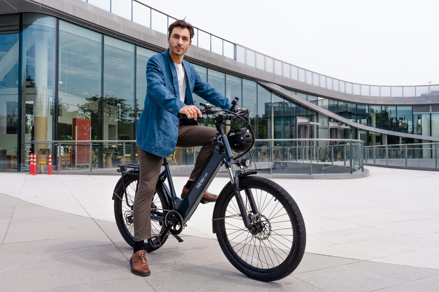 Business-casual commuter on an e-bike outside a modern office building