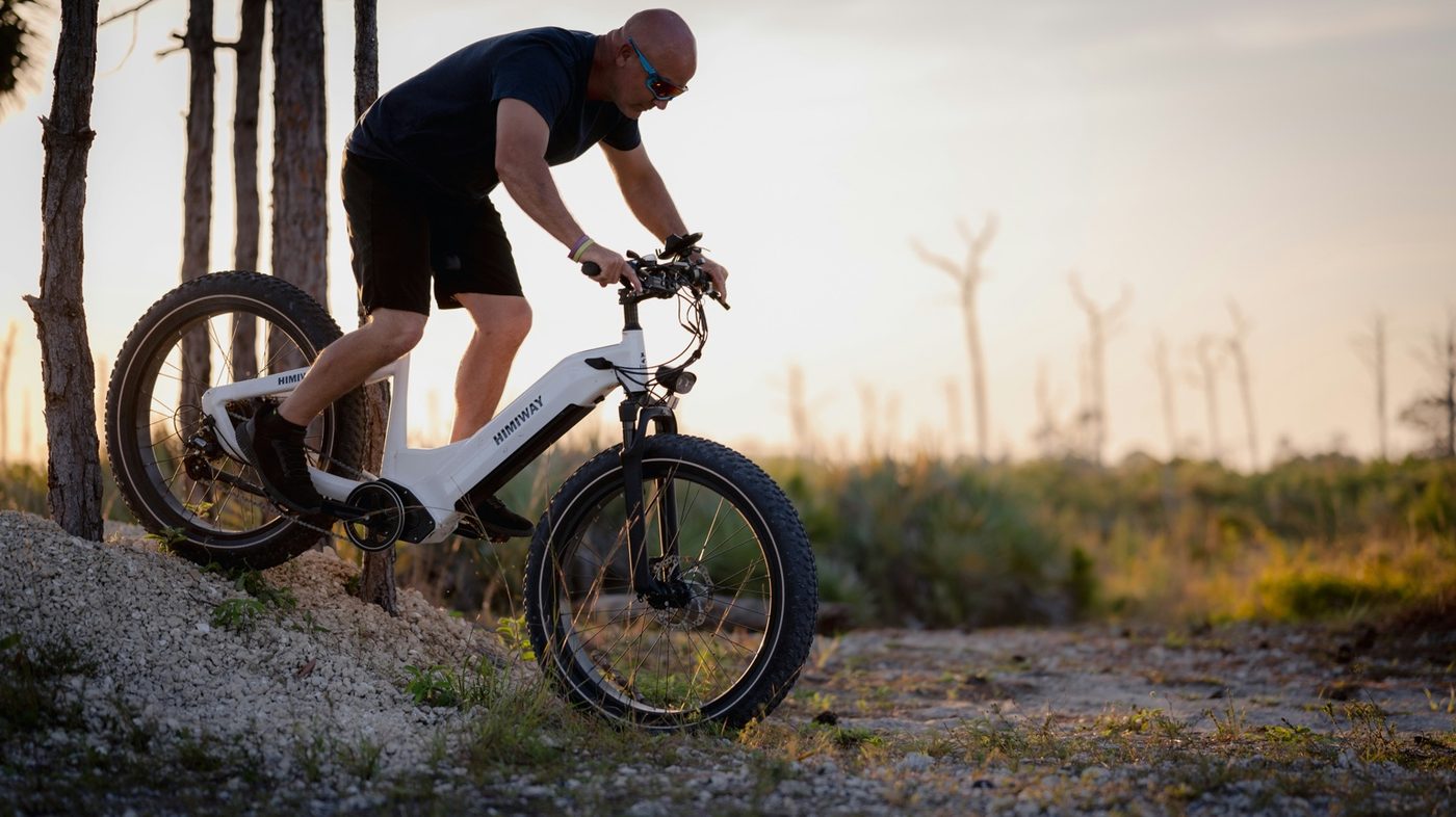 Rider on a white fat-tire e-bike descending rough terrain