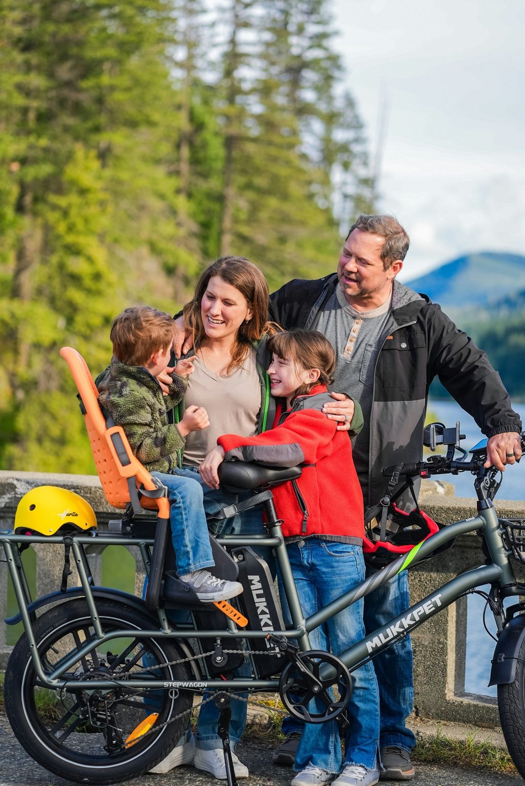 Family standing beside a cargo e-bike with a child seat and passenger setup