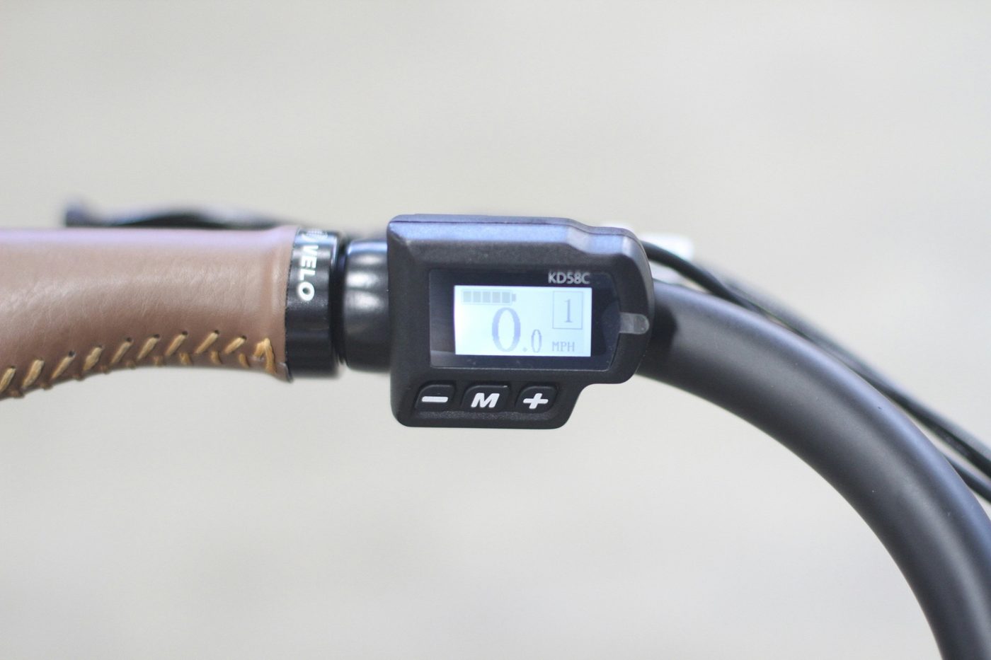 Simple e-bike display and controls close-up on a swept-back handlebar